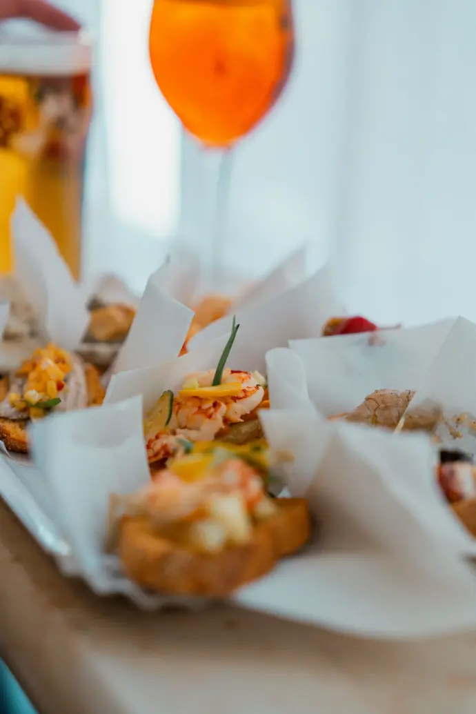 Appetizers are served with a vibrant orange cocktail.